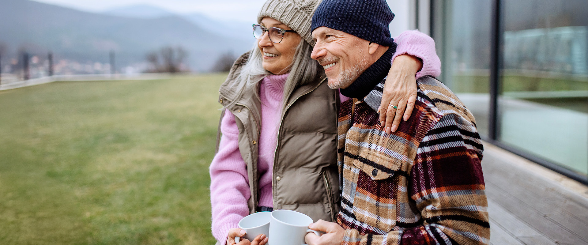 Ein älteres Paar sitzt entspannt auf ihrer sanierten Terrasse